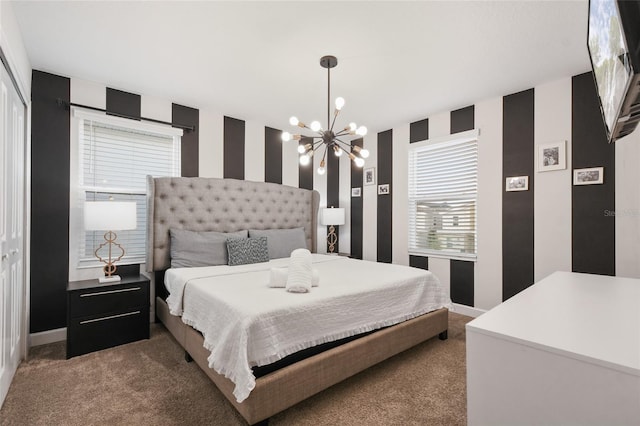 bedroom featuring dark colored carpet, an inviting chandelier, multiple windows, and a closet