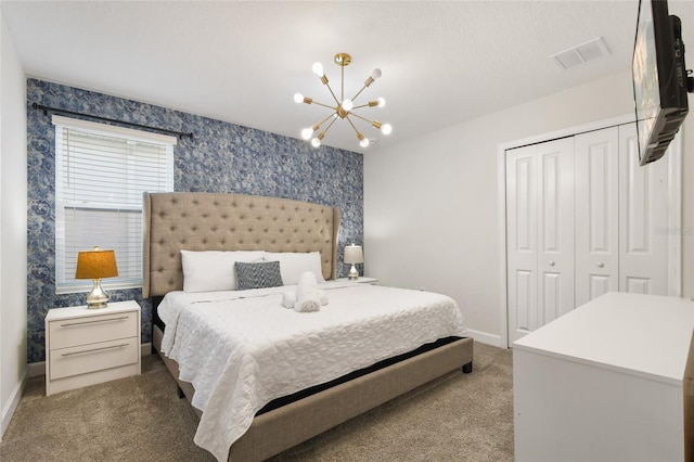 carpeted bedroom featuring a chandelier and a closet