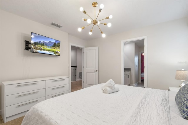 bedroom featuring a notable chandelier and ensuite bathroom