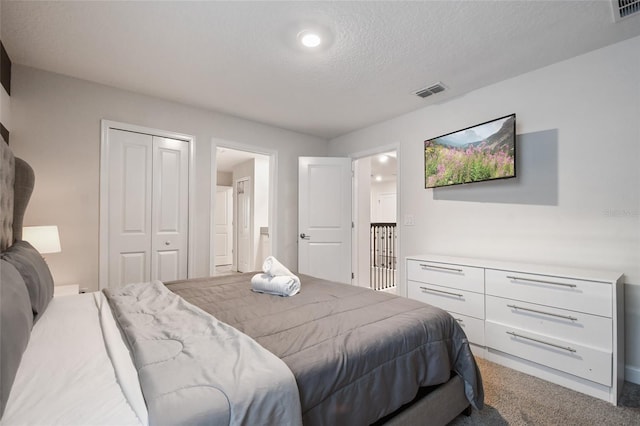 carpeted bedroom featuring a textured ceiling and a closet