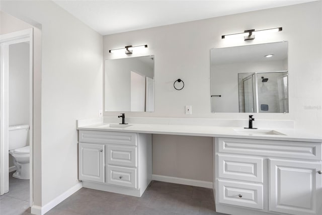 bathroom with tile patterned flooring, vanity, toilet, and a shower with shower door