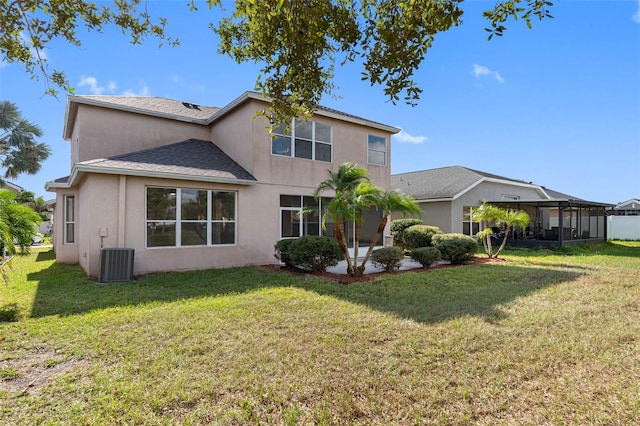 back of property with a lawn and central AC