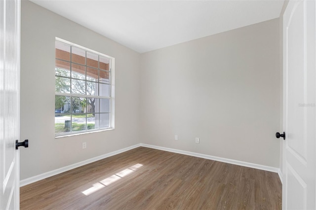 unfurnished room with baseboards and dark wood-style flooring