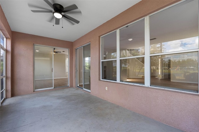 unfurnished sunroom with a ceiling fan and a healthy amount of sunlight