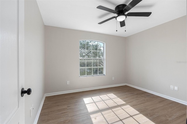 empty room with a ceiling fan, light wood-style flooring, and baseboards