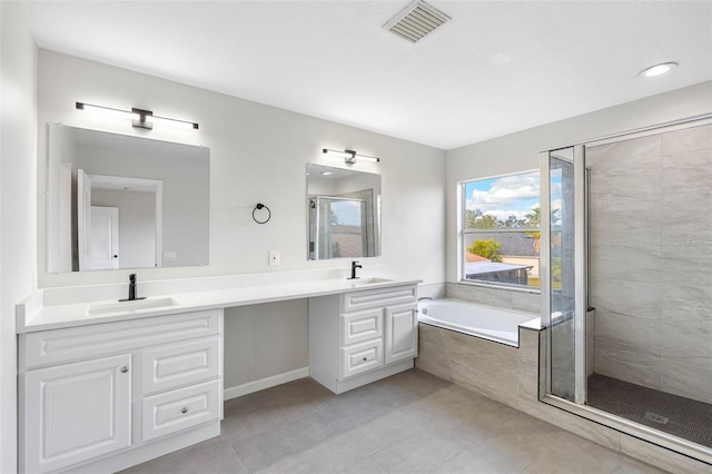 full bath with a bath, double vanity, a sink, and visible vents