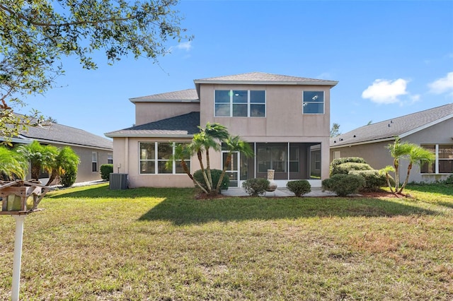 rear view of property featuring central AC, a lawn, and stucco siding