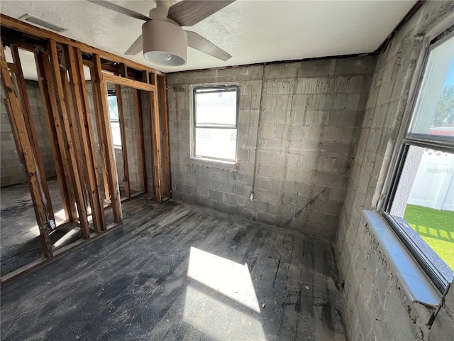 507 79th Ave, St Pete Beach, FL 33706 - unfurnished room featuring concrete block wall, wood finished floors, and ceiling fan