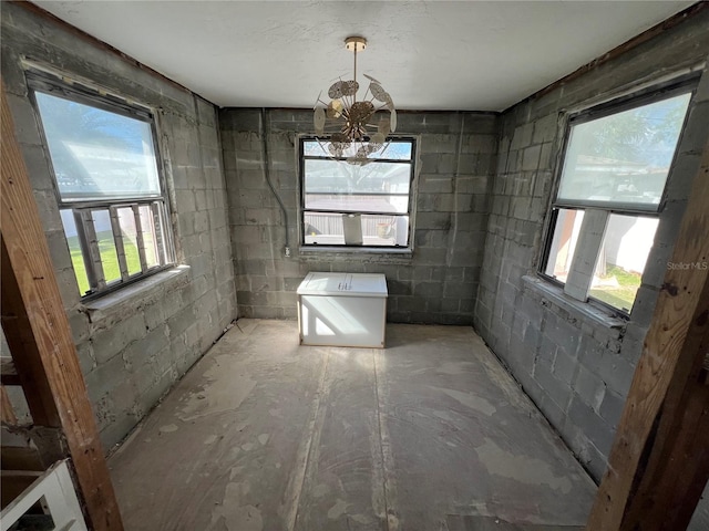 507 79th Ave, St Pete Beach, FL 33706 - bathroom featuring concrete block wall and a chandelier