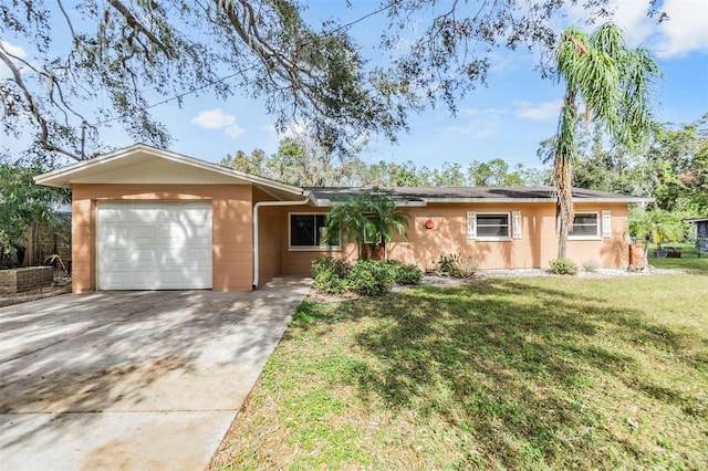 single story home featuring driveway, a front lawn, and an attached garage