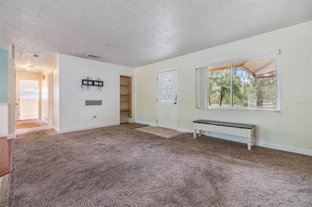 unfurnished living room featuring radiator heating unit, carpet, and a textured ceiling