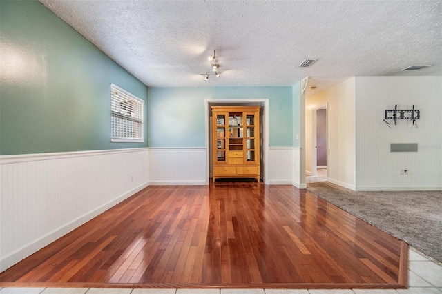 empty room featuring a textured ceiling and hardwood / wood-style flooring