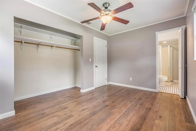 unfurnished bedroom featuring ceiling fan, ornamental molding, connected bathroom, wood-type flooring, and a closet