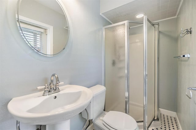 bathroom with tile patterned floors, ornamental molding, a shower with door, sink, and toilet