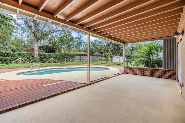 view of pool featuring a shed, a yard, a patio, and a deck