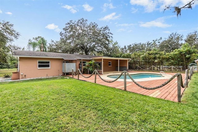 rear view of property featuring a fenced in pool and a yard