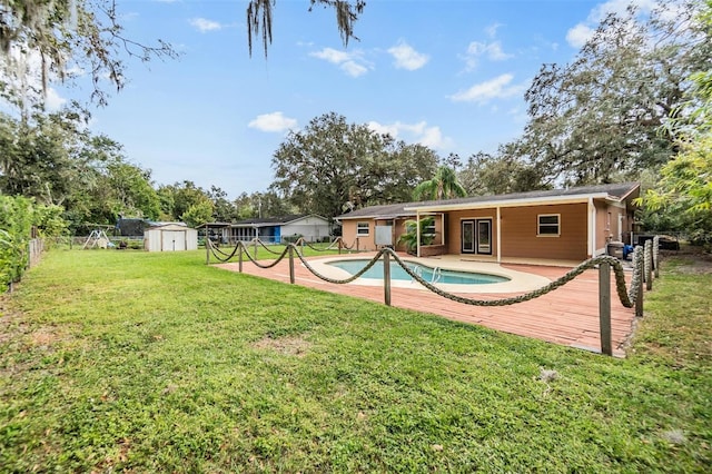 view of pool featuring a patio area, a shed, and a yard