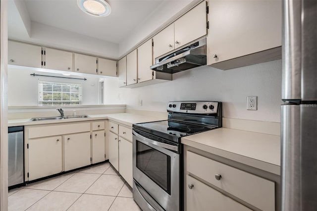 kitchen featuring a sink, under cabinet range hood, stainless steel appliances, light countertops, and light tile patterned floors