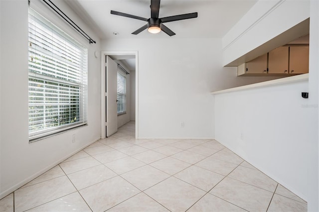 empty room with light tile patterned floors and a ceiling fan