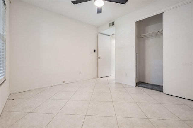 unfurnished bedroom with light tile patterned floors, a closet, visible vents, and ceiling fan