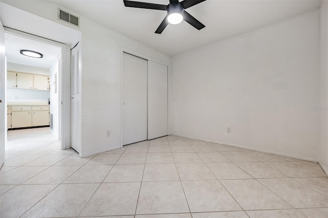 unfurnished bedroom featuring light tile patterned floors, visible vents, and ceiling fan