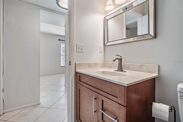 bathroom featuring baseboards, toilet, vanity, and tile patterned flooring