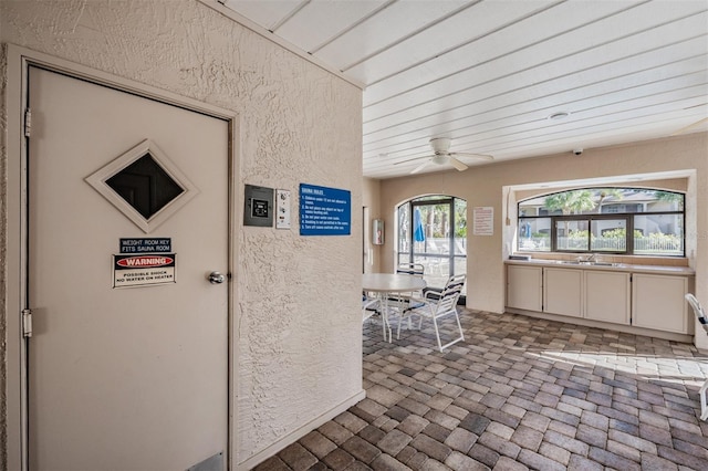 view of patio featuring outdoor dining space, a ceiling fan, and a sink