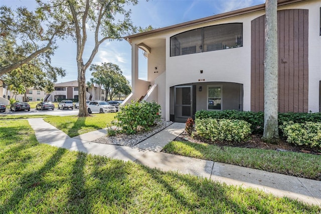 view of property with stucco siding and a front lawn