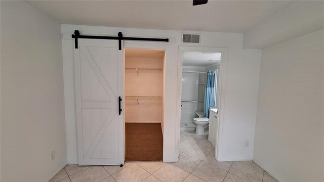 bathroom with tile patterned floors, toilet, a shower, and visible vents