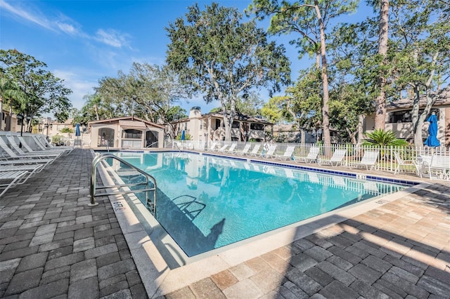 pool with a patio area and fence