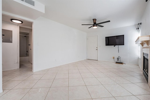 unfurnished living room featuring visible vents, a ceiling fan, electric panel, a fireplace, and light tile patterned floors