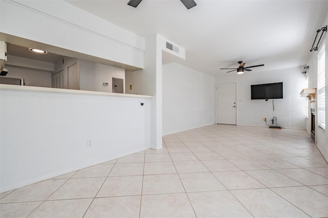 unfurnished living room featuring light tile patterned floors, a fireplace, visible vents, and ceiling fan