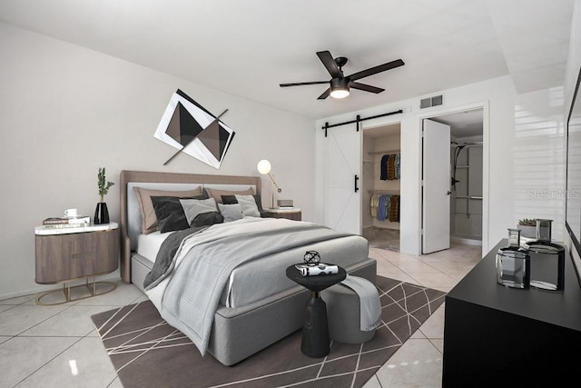 bedroom with light tile patterned flooring, visible vents, ceiling fan, and a barn door