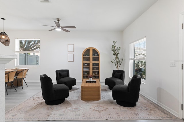 living area featuring ceiling fan and light hardwood / wood-style floors