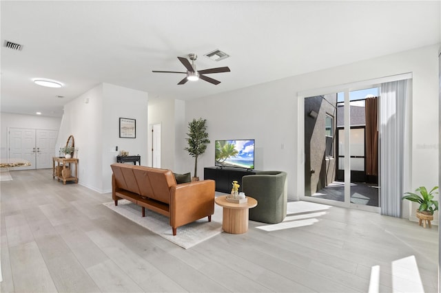 living room with ceiling fan and light hardwood / wood-style flooring