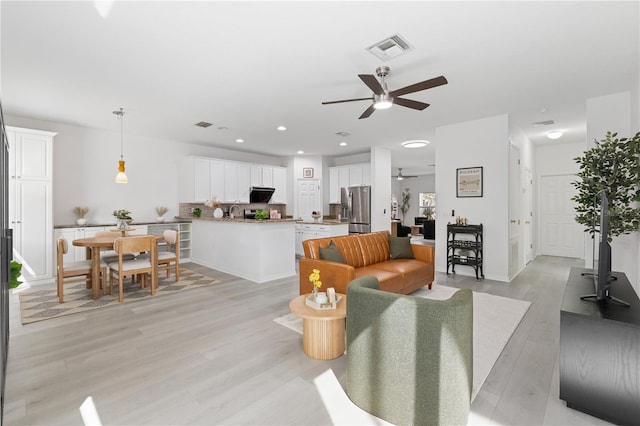 living room with ceiling fan and light hardwood / wood-style floors