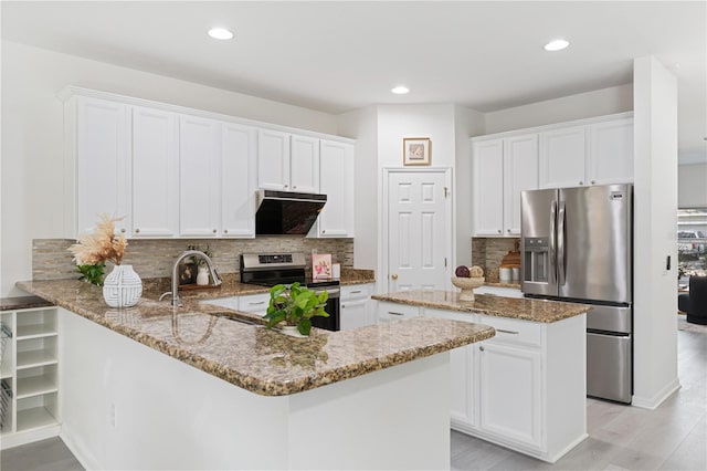 kitchen featuring white cabinets, light stone countertops, stainless steel appliances, and extractor fan