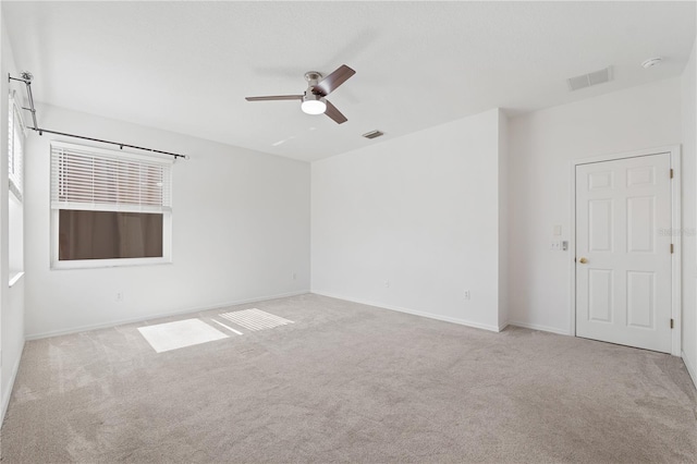 empty room featuring light colored carpet and ceiling fan