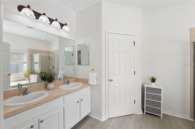 bathroom with hardwood / wood-style floors, vanity, and an enclosed shower