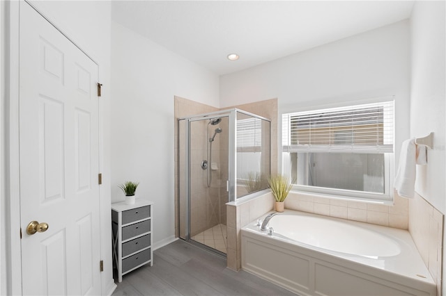 bathroom with hardwood / wood-style floors and independent shower and bath