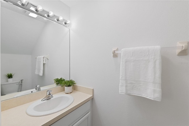 bathroom with vanity, toilet, and vaulted ceiling