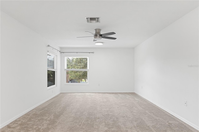 spare room with ceiling fan and light colored carpet