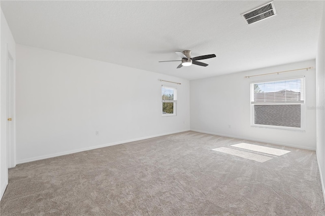 carpeted empty room featuring ceiling fan and a textured ceiling