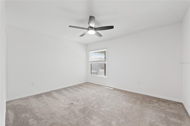 spare room with ceiling fan and light colored carpet