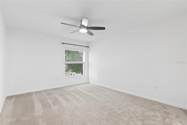 spare room with light colored carpet and ceiling fan