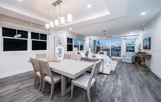 dining space with ceiling fan with notable chandelier, dark hardwood / wood-style flooring, and crown molding