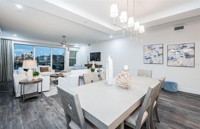 dining area with ceiling fan with notable chandelier and dark hardwood / wood-style flooring