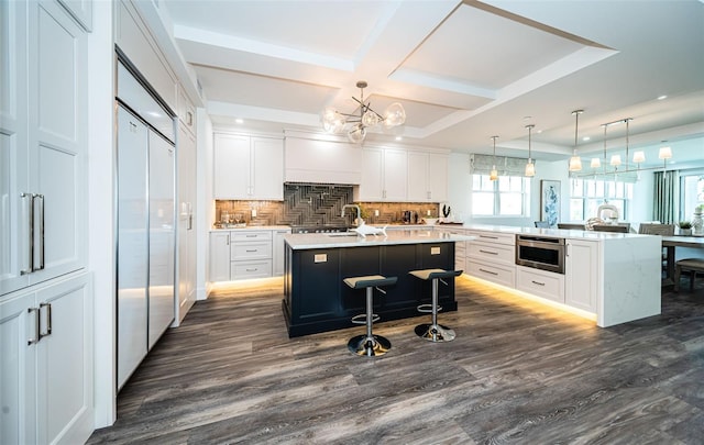 kitchen featuring white cabinets, a center island, and dark hardwood / wood-style flooring