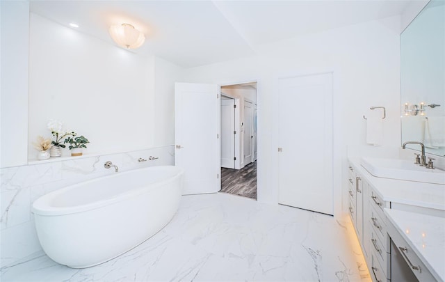 bathroom with a washtub and vanity