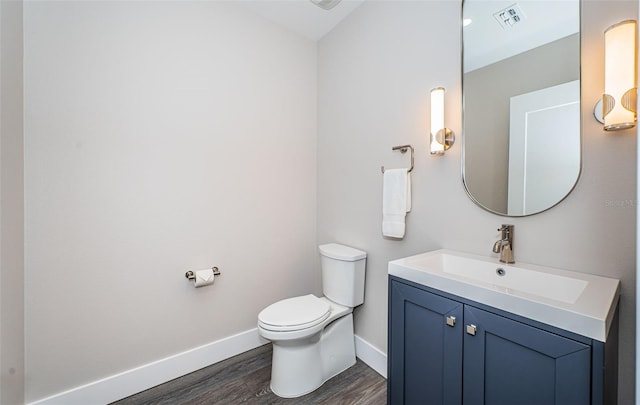 bathroom with hardwood / wood-style floors, vanity, and toilet